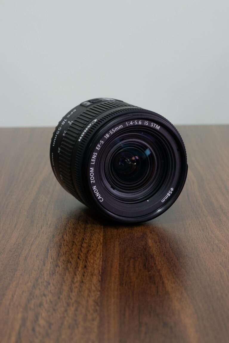 Capture the beauty of a Canon zoom lens with detailed focus on a wooden table, perfect for photography enthusiasts.