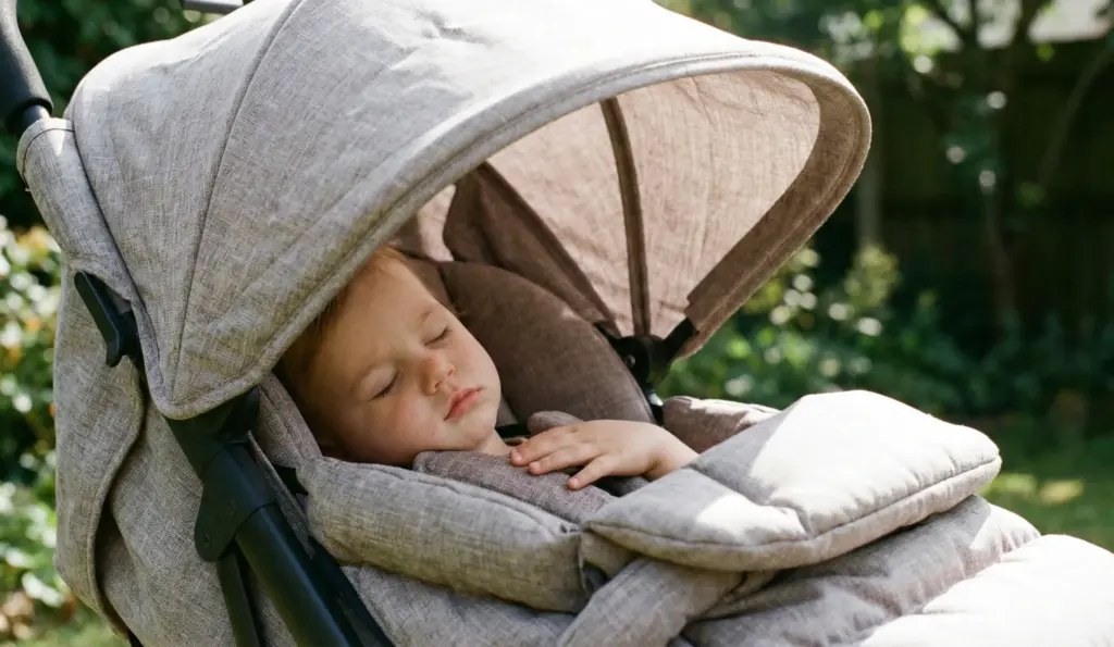 Kind sitzt bequem im gepolsterten Sitz des Bugaboo Bee 6 mit großem Sonnenverdeck.